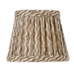 The Zafferano America x Fermoie Poldina Lampshade Collection features a hand-made, pleated lampshade in brown and white stripes, displayed against a white background.