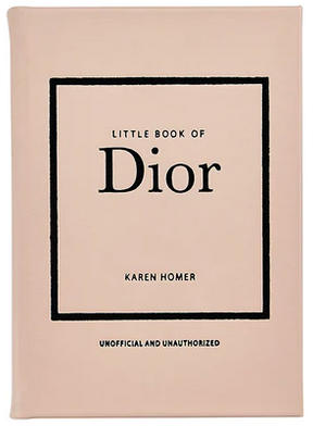 The cover of the "Little Book of Dior" by Graphic Image, showcasing a minimalist design with a blush pink background and black text, captures the essence of Parisian haute couture and honors Christian Dior's iconic new look silhouette.