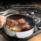 A person searing steak in the Hestan NanoBond Covered Sauté pan on a gas stove, with text highlighting its superior ProCore heat conductivity.