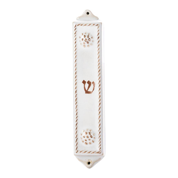 The Juliska Berry & Thread Whitewash Mezuzah is a white ceramic case with Berry & Thread detailing, a central brown "Shin," and wall-mounting holes at the top and bottom.