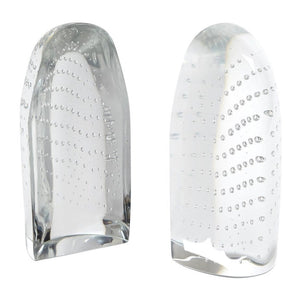 The Dewdrop Iceberg Bookends by Global Views feature two upright, clear glass sculptures with frosted and polished finishes, showcasing curved lines of tiny air bubbles inside—evoking floating icebergs.