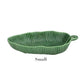 A small, green, leaf-shaped ceramic dish with a ribbed texture and handle. Handmade by HIVE, this piece from the Banana Leaves Salad Bowl Collection brings charm to any table setting.