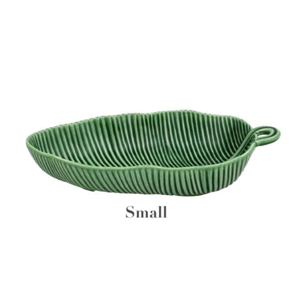 A small, green, leaf-shaped ceramic dish with a ribbed texture and handle. Handmade by HIVE, this piece from the Banana Leaves Salad Bowl Collection brings charm to any table setting.