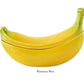 The Bananas From Madeira Serveware Collection by Bordallo Pinheiro features a ceramic banana-shaped container with lid—a fun, playful addition to your serveware.