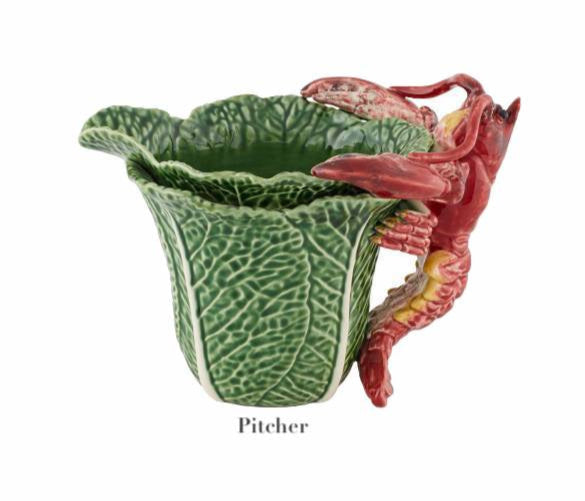 The HIVE Cabbage with Lobsters Serveware Collection features a handmade ceramic pitcher shaped like a green cabbage leaf with a red lobster handle, labeled "Pitcher" and shown on a white background. A unique serveware accent.
