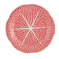 A round ceramic plate from Hive's Pink Cabbage Leaf Dinnerware and Serveware Collection, featuring a pink and white design reminiscent of delicate leaf patterns.