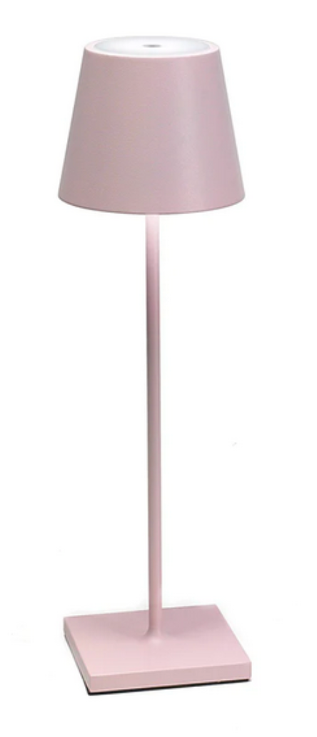 The Poldina Pro Lamp Collection by Zafferano America features a minimalist pink rechargeable lamp with a conical shade, slim vertical stem, and square base, providing cordless illumination against a plain white background.