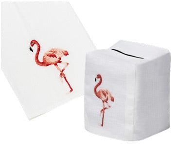 From the Haute Home Flamingo Coaster & Bath Collection: a white tissue box cover and matching napkin, both expertly crafted from premium linen and adorned with an embroidered pink flamingo standing on one leg.