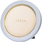 The Piero Leather Frame Collection by Aerin features a round tabletop mirror with a light blue frame, Italian leather accents, and gold detailing for an elegant display.