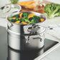 The Hestan Provisions Stainless Steel Steamer Insert, 3qt, holds broccoli and sliced yellow bell peppers as it rests on an electric stovetop.