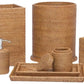 The Dalton Bath Collection by Pigeon & Poodle features six handmade rattan accessories—wastebasket, tissue box cover, soap dispenser, tray, lidded jar, and cup with toiletries—crafted using organic dyes and fine detail.