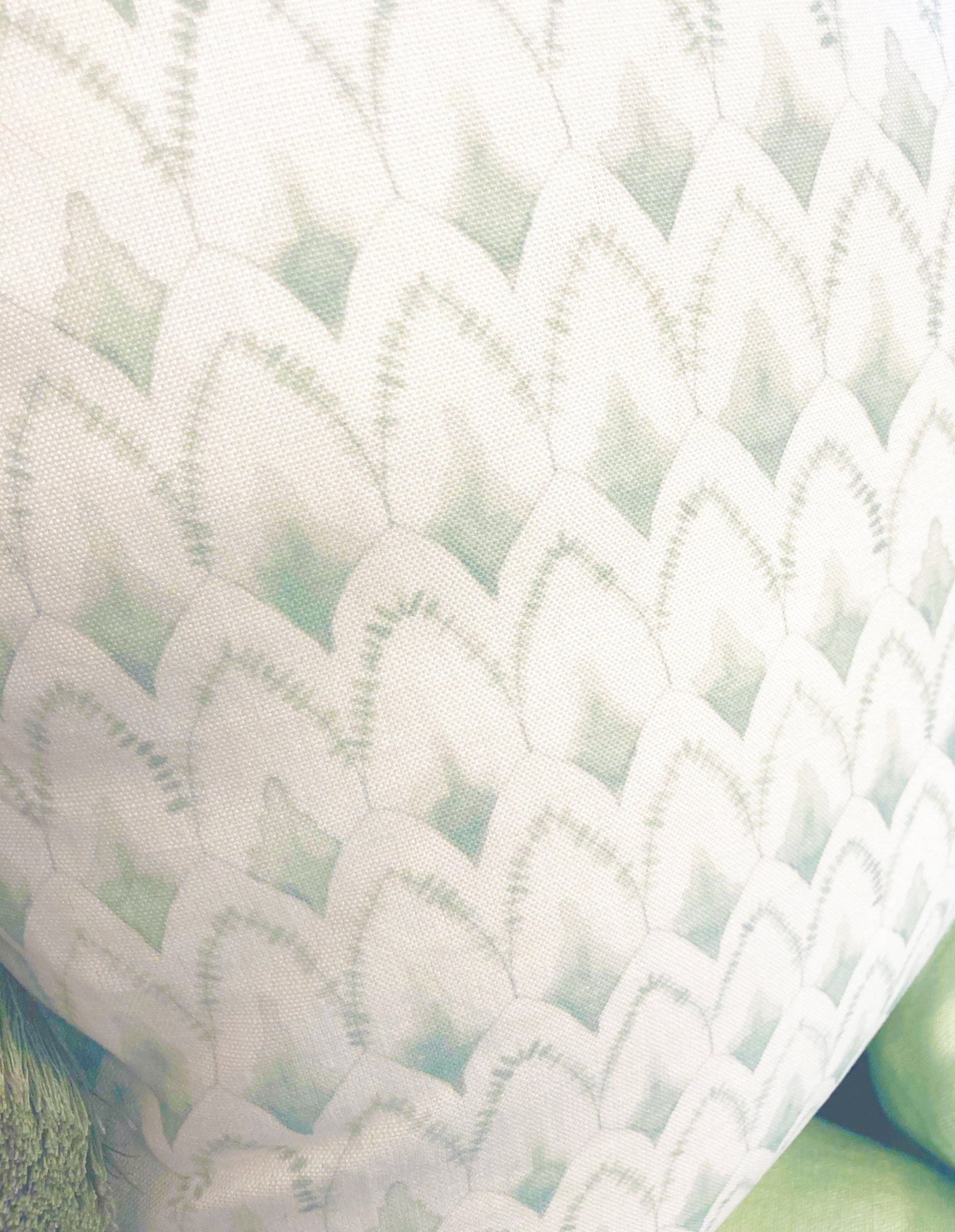 Close-up of the 22" x 22" Arrowhead Rainwashed Pillow by Hive Custom Pillows, featuring a repeating scallop pattern in light green and white tones.