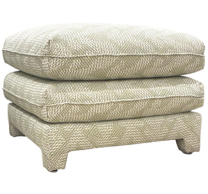 The Empire Ottoman by Bunny Williams features a square, light green patterned upholstery with two stacked cushion layers and short block legs, making it a versatile addition to any bedroom.
