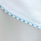 Close-up of Haute Home's Smart Pajama Pant Set: white cotton sateen fabric with blue and white checkered trim, showcasing the refined details of this luxury sleepwear.