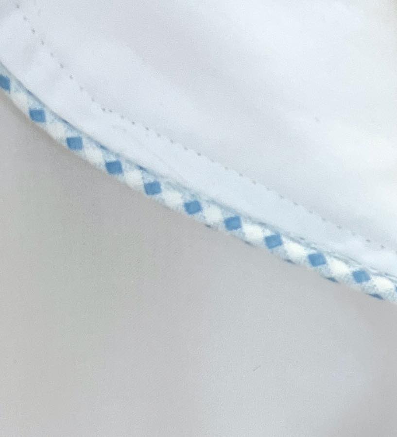 Close-up of Haute Home's Smart Pajama Pant Set: white cotton sateen fabric with blue and white checkered trim, showcasing the refined details of this luxury sleepwear.