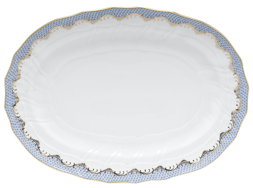 The Herend Fish Scale Platter in Light Blue is an empty oval porcelain serving piece with a scalloped edge, gold trim, and a blue patterned border featuring elegant hand-painted designs.