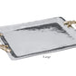 The Ocean Coral Emerson Tray from Beatriz Ball’s collection features a large rectangular silver aluminum alloy tray with a hammered finish and decorative gold branch-shaped handles on both sides.