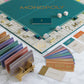 WS Game Company's Monopoly Del Mar Shagreen Edition features premium components, including cards, money, dice, and tokens arranged on a marble surface for an elevated gaming experience.