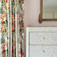Floral curtains beside a Made Goods Lexi Dresser featuring an Indian leaf pattern; a framed mirror is partially visible on the pale pink wall.