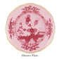 A pink dinner plate from Ginori 1735's Oriente Italiano Porpora collection, featuring Italian elegance with floral and landscape motifs, scalloped edges, and a gold rim.