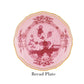 The Oriente Italiano Porpora Bread Plate by Ginori 1735 features pink porcelain, a gold-trimmed edge, and a red floral center—an elegant Italian touch. Text below reads "Bread Plate.