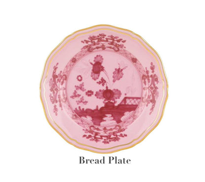 The Oriente Italiano Porpora Bread Plate by Ginori 1735 features pink porcelain, a gold-trimmed edge, and a red floral center—an elegant Italian touch. Text below reads "Bread Plate.