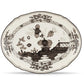 The Oriente Italiano Albus Dinnerware Collection by Ginori 1735 features ornate porcelain plates with scalloped edges, adorned with black floral and landscape patterns on a white background.