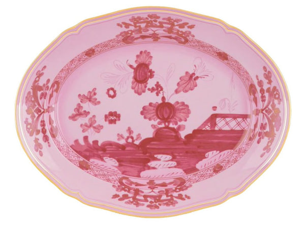 The GINORI 1735 Oriente Italiano Porpora Oval Platter from Ginori 1735 features a pink floral and landscape design with intricate patterns around the border, showcasing traditional Italian craftsmanship.