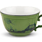 A green ceramic teacup from the Ginori 1735 Oriente Italiano Malachite Dinnerware Collection, featuring a floral design and white interior, is shown against a plain white background.