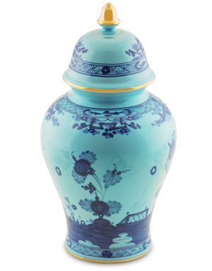 The Ginori 1735 Oriente Italiano Iris with Gold Vase and Cover features a tall white ceramic body, dark blue floral patterns, yellow accents on the lid and rim, and elegant gold details.