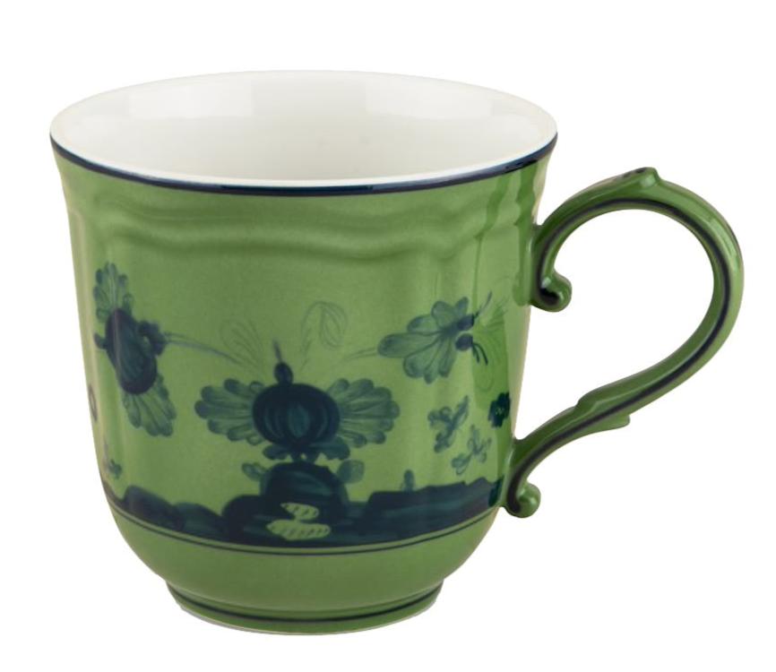 The Oriente Italiano Malachite Mug by Ginori 1735 showcases a green ceramic finish with a dark blue floral motif and scalloped handle, inspired by Faenza ceramics, displayed on a white background.