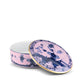 The Oriente Italiano Azalea Serveware & Decor Collection by Ginori 1735 features a round porcelain box with blue floral and landscape patterns on a pink background, gold rim accents, and a removable lid—ideal for elegant home decor.