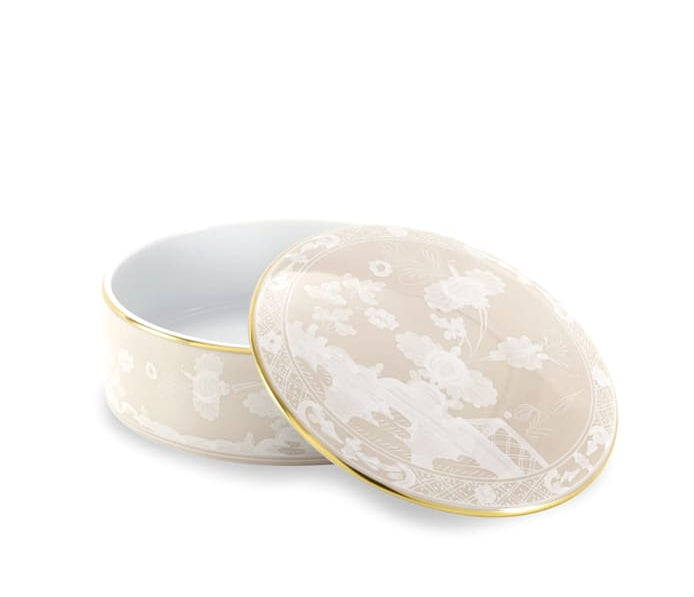 A round porcelain box from Ginori 1735’s Oriente Italiano Meringa Dinnerware & Serveware Collection features a floral motif and gold trim, shown with its matching lid slightly ajar—a striking piece for elegant table settings.