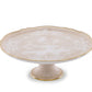 The Oriente Italiano Meringa cake stand from Ginori 1735 features a cream hue, gold trim, and floral motifs—an elegant addition to any tableware collection.