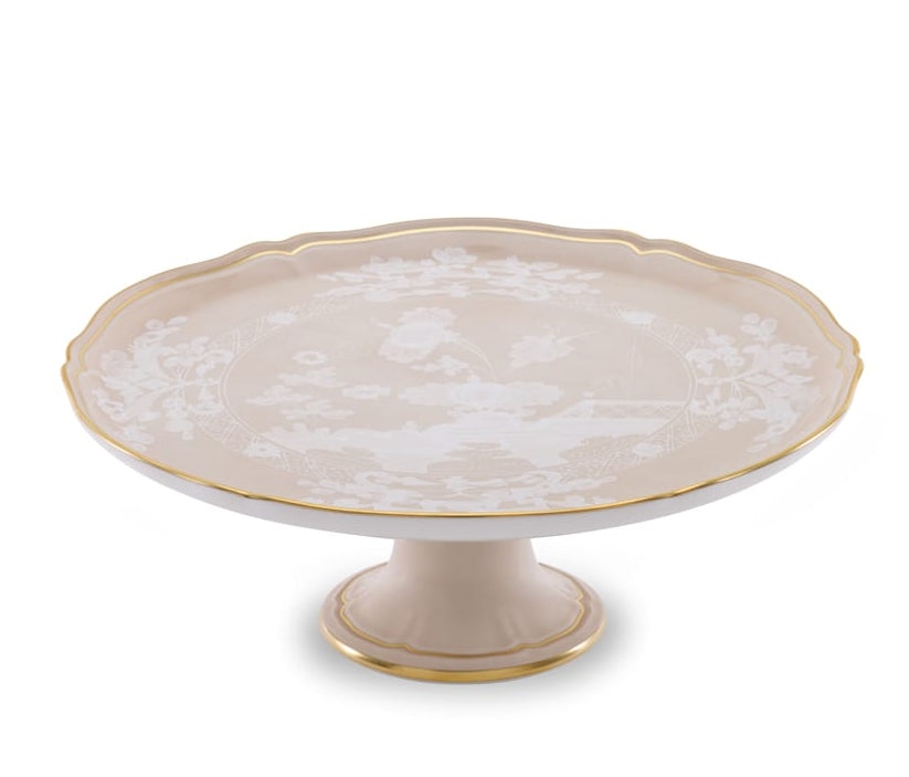 The Oriente Italiano Meringa cake stand from Ginori 1735 features a cream hue, gold trim, and floral motifs—an elegant addition to any tableware collection.