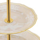 Close-up of a two-tiered Ginori 1735 Oriente Italiano Meringa serving tray featuring decorative white floral patterns on clear plates and a gold-toned stand.