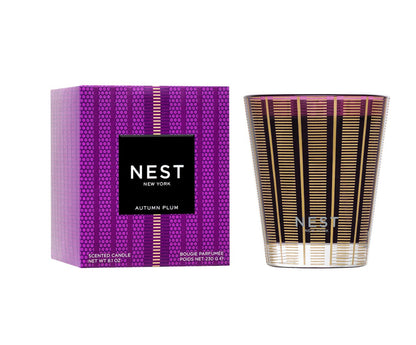 The Nest Autumn Plum Candle Collection features a premium scented candle and a purple patterned box with gold and black accents, perfect for bringing fall elegance into your home.