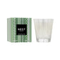 The Nest Birchwood Pine Collection candle, in clear patterned glass beside its green box with a black-and-white label, fills your space with a winter forest scent for a festive atmosphere.