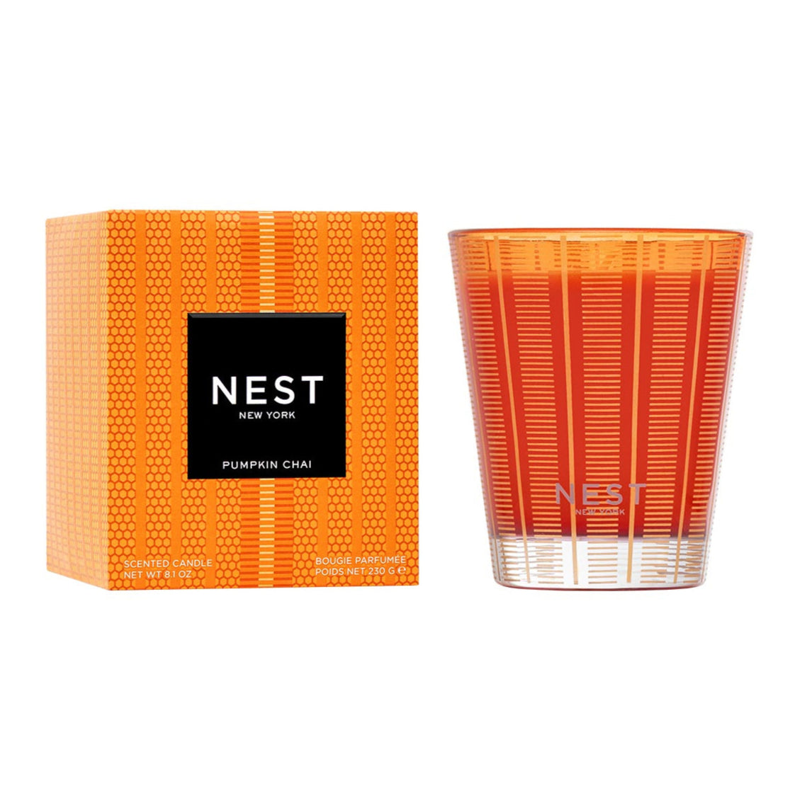 A Nest Pumpkin Chai Candle from the Pumpkin Chai Candle Collection sits by its matching box, both with geometric designs and black labels—ideal for creating a cozy autumn ambiance.