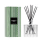 The Nest Birchwood Pine Collection reed diffuser features a patterned green box and clear glass bottle with black reeds, capturing the scent of a winter forest.
