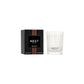 The Nest Something Tropical Candle from the Candle and Diffuser Collection sits in a clear glass jar beside its black box, offering vibrant passion fruit and soft cashmere woods notes for an inviting fragrance experience.