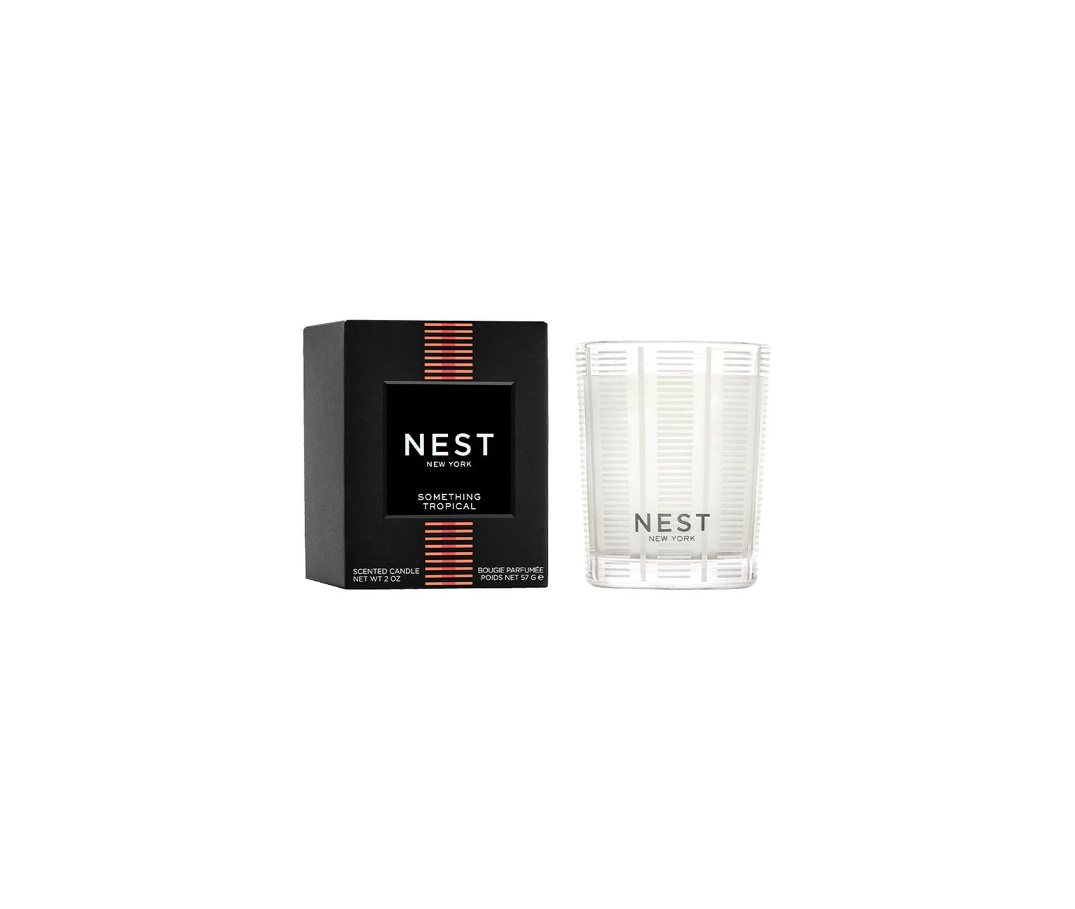 The Nest Something Tropical Candle from the Candle and Diffuser Collection sits in a clear glass jar beside its black box, offering vibrant passion fruit and soft cashmere woods notes for an inviting fragrance experience.