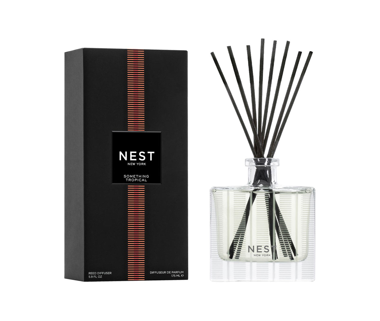 The Nest Something Tropical Candle and Diffuser Collection features a sleek black box and clear reed diffuser, both with matching labels, capturing the essence of passion fruit and cashmere woods.