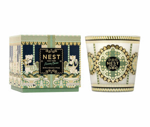 A 3-wick Pierre Marie Birchwood Collection candle in a matching glass vessel and decorative box, featuring intricate geometric and carousel-themed patterns in green, gold, and dark blue.
