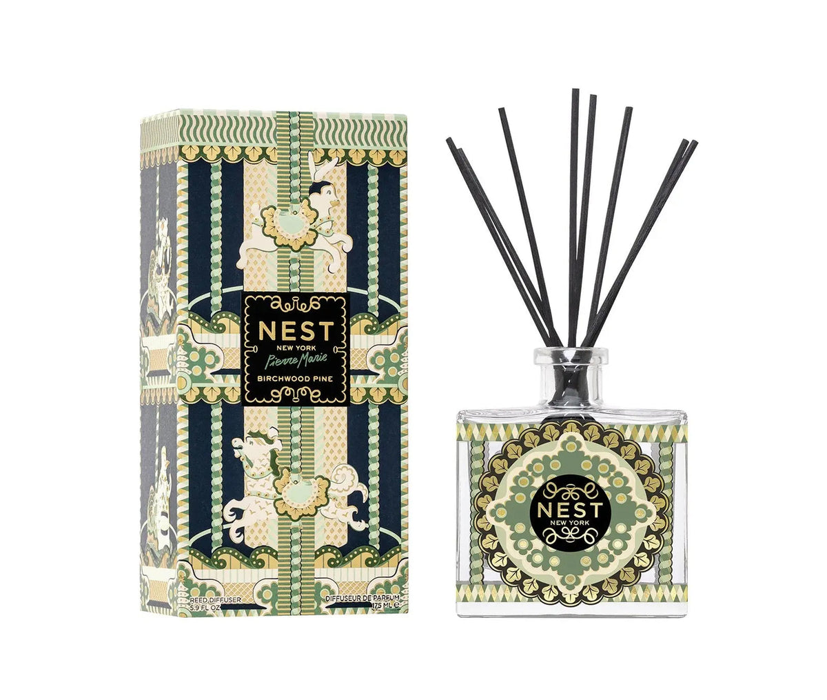 A Nest Pierre Marie Birchwood Collection reed diffuser with a patterned glass bottle and black reeds, shown next to its matching decorative box.