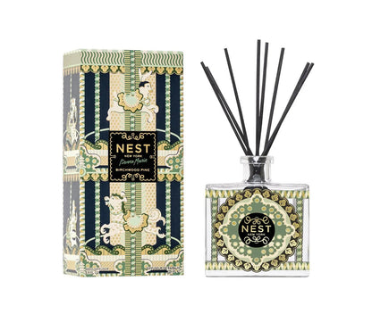 A Nest Pierre Marie Birchwood Collection reed diffuser with a patterned glass bottle and black reeds, shown next to its matching decorative box.