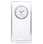 The Woodbury Tall Clock by Simon Pearce features a rectangular clear glass body, a round white face with black hour and minute hands, and "Simon Pearce" elegantly printed on the dial.