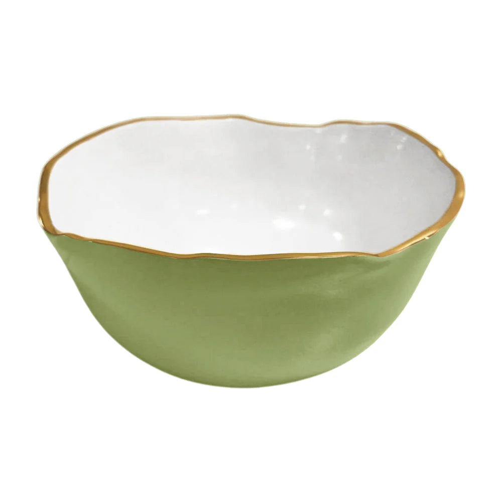 A green enamel ceramic bowl from the Beatriz Ball ENCANTO Collection, featuring a white interior and irregular gold-toned rim accents, viewed at an angle.