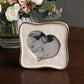 The Beatriz Ball Encanto Curved Heart Frame Collection, 5x5, showcases a black and white photo of a woman and child on a wooden table next to a vase filled with white and pink flowers.