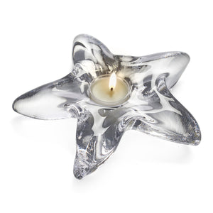 A lit tealight candle sits in a Simon Pearce Starfish Glassware Collection bowl on a white background—a perfect summer host or beachcombing gift.